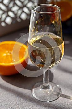 Glass with cold fino sherry fortified wine in sunlights, andalusian style interior on background