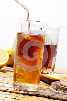 Glass of cold ice tea with lemon, condensate on glass
