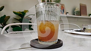 A glass of cold iced tea on a white table