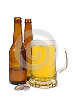 Glass of cold lager pils beer with brown bottles isolated on white background