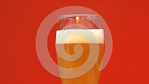 Glass of cold light beer with foam, refreshing summer craft drink, close up