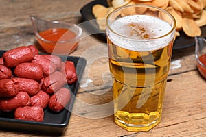 Glass of cold light beer with snacks