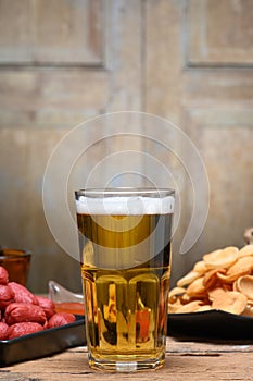Glass of cold light beer with snacks