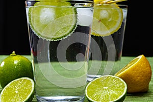 Glass with cold sparkling mineral water, lime and lemon