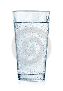 Glass of cold sparkling water with drops photo