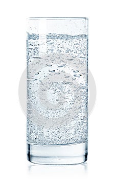 Glass of cold sparkling water on white background