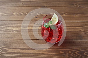 glass of cold tea red drink isolated on wooden table