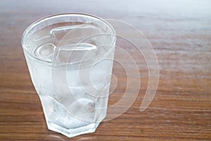 Glass of cold water on wooden table