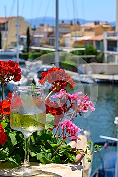 Glass of cold white wine in yacht harbour of Port Grimaud, summer vacation on French Riviera in Provence, France