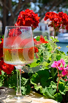 Glass of cold white wine in yacht harbour of Port Grimaud, summer vacation on French Riviera in Provence, France