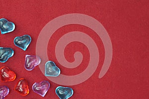 Glass colored hearts on a red background. Valentines day. Place for text.