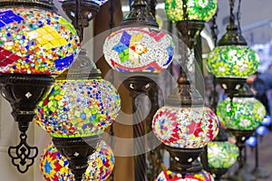 Glass, colorful, traditional, decorative Turkish lamps hang on the ceiling in the store