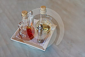 Glass condiment set with olive oil, vinegar, salt and pepper on kitchen table