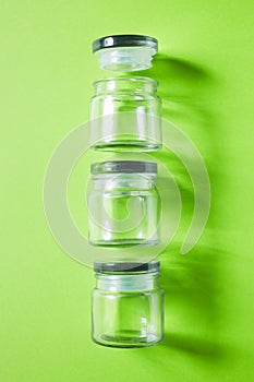 Glass containers on green background, from above