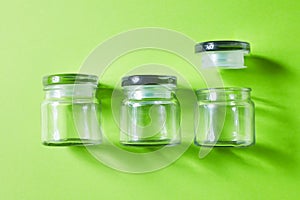 Glass containers on green background, from above