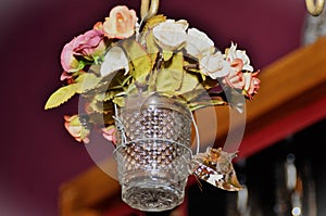 A glass cup with artificial flowers with a Hypna clytemnestra butterfly