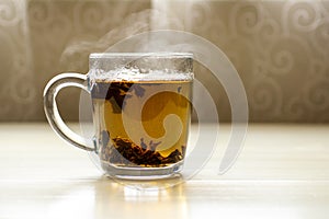 A glass cup of black hot tea on a light table