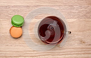 Glass cup of black tea and colorful macarons
