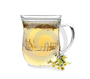 Glass cup of camomile tea on white background