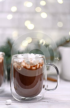 Glass cup of cocoa on the buckground of gold bokeh, New Year hot drink