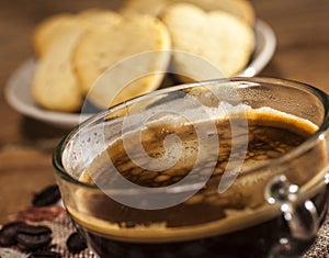 Glass cup with coffee and cookies in a heart shape