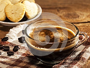 Glass cup with coffee and cookies in a heart shape