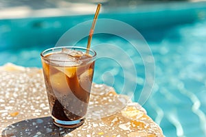 Glass cup contains iced coffee with straw in poolside background. Generative AI
