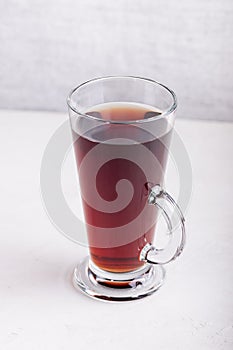 Glass cup with drink on gray concrete background