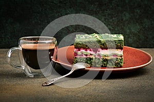 Glass cup with espresso and a cake with Japanese Matcha tea and raspberries, close-up, sweet dessert