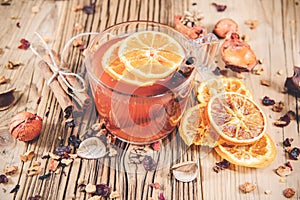 Glass cup of fruit tea with dry orange and cinnamon