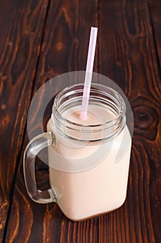 Glass cup of hot cocoa with milk and with straw tube