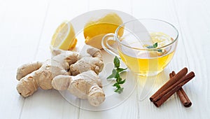 Glass cup of hot tea with ginger, lemon, mint and cinnamon