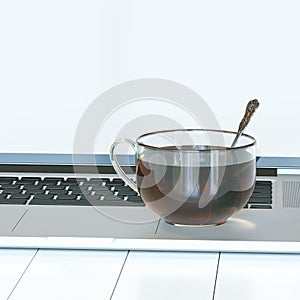 Glass cup of hot tea on laptop on white hardwood table. Front vi