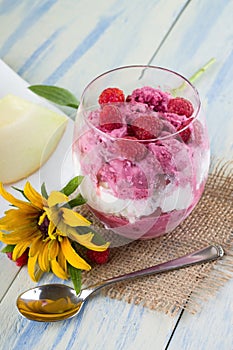 Glass cup with ice cream with spoon and flower