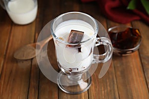 Glass cup of milk with delicious grass jelly on wooden table, closeup