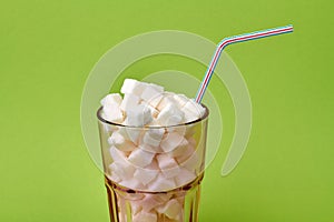 Glass cup overfilled with sugar cubes.