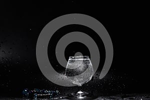 Glass cup with pure mineral water with bubbles on a black background