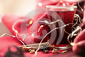 a glass cup of a red warming drink (tea, mulled wine, punch). ingredients for winter hot drinks. beautiful background