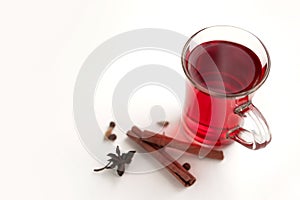 a glass cup of a red warming drink (tea, mulled wine, punch). ingredients for winter hot drinks