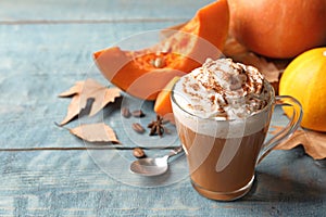 Glass cup with tasty pumpkin spice latte and space for text