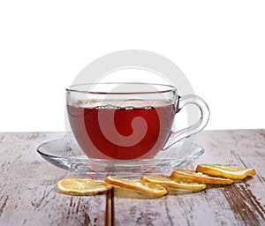 Glass cup with tea and a lemon on a glass