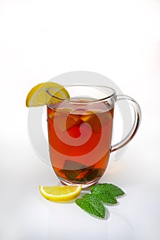Glass cup of tea with lemon slices and mint leaves