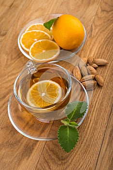 Glass cup of tea with mint and lemon, almond