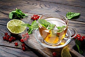 Glass cup of tea with mint on wooden table