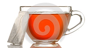 Glass cup with tea and tea bag close up on white isolated background