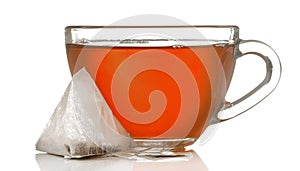 Glass cup with tea and tea bag close up on white isolated background