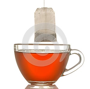 Glass cup with tea and tea bag close up on white isolated background