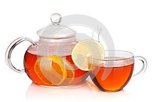 Glass cup and teapot of black tea with lemon