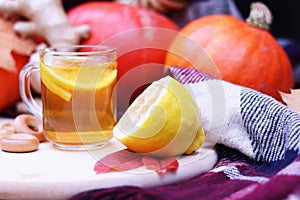 Glass cup with warm tea with lemon close-up. Autumn composition