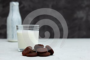 A glass cup of yogurt, yogurt or ayran on a white table, next to it lies a handful of dried fruits, dried dried apricots. In the